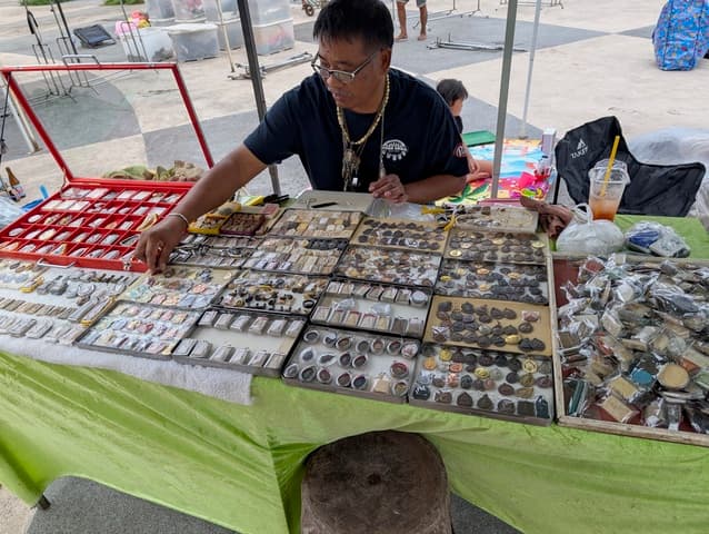 Vendeur d'amulettes bouddhistes thaïlandaises avec ses plateaux